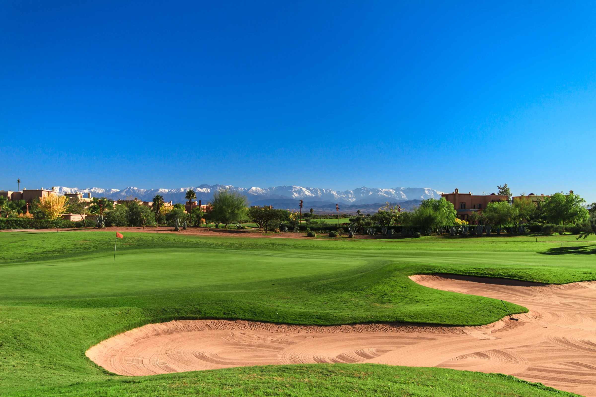 Les greens et les bunkers du golf de Samanah, avec les sommets enneigés de l’Atlas à l’horizon